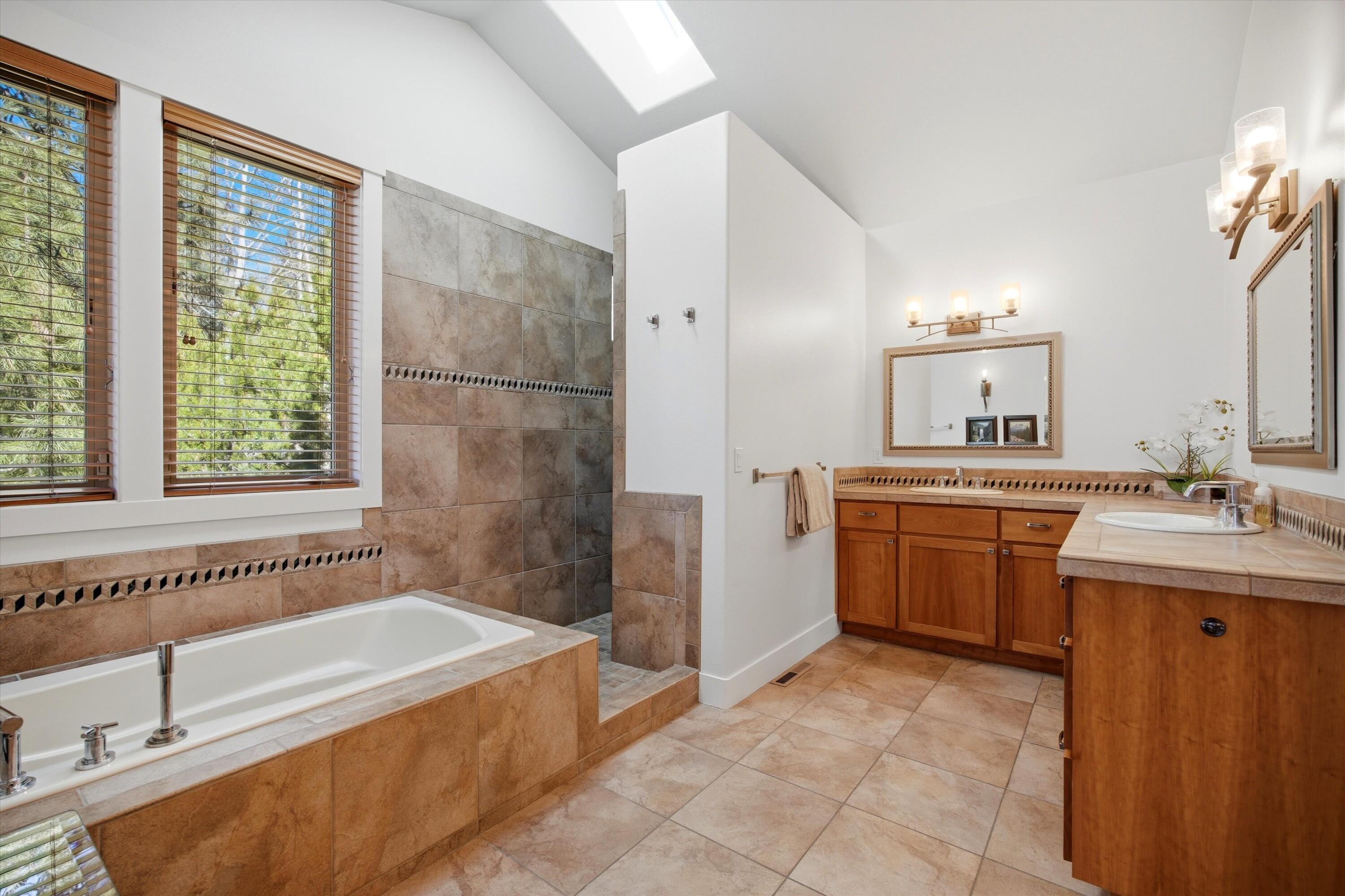 15 Southwest Quail Butte Place Bend, OR 97703 - Photo 24 of 55 a spacious bathroom with a tub sink and mirror