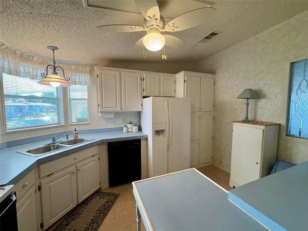a kitchen with a sink a stove a refrigerator and cabinets