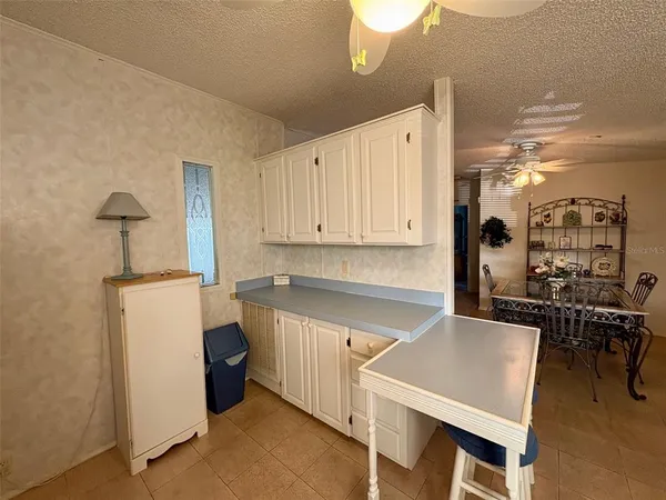 a kitchen with a table chairs refrigerator and cabinets