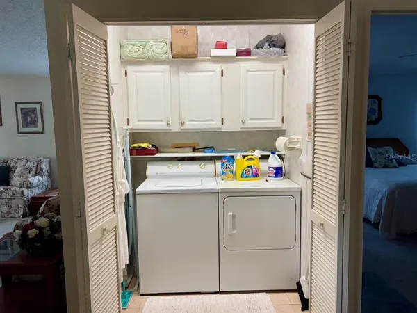 a utility room with cabinets washer and dryer