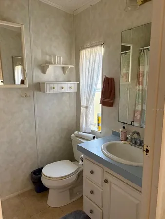 a bathroom with a toilet a sink a mirror and vanity