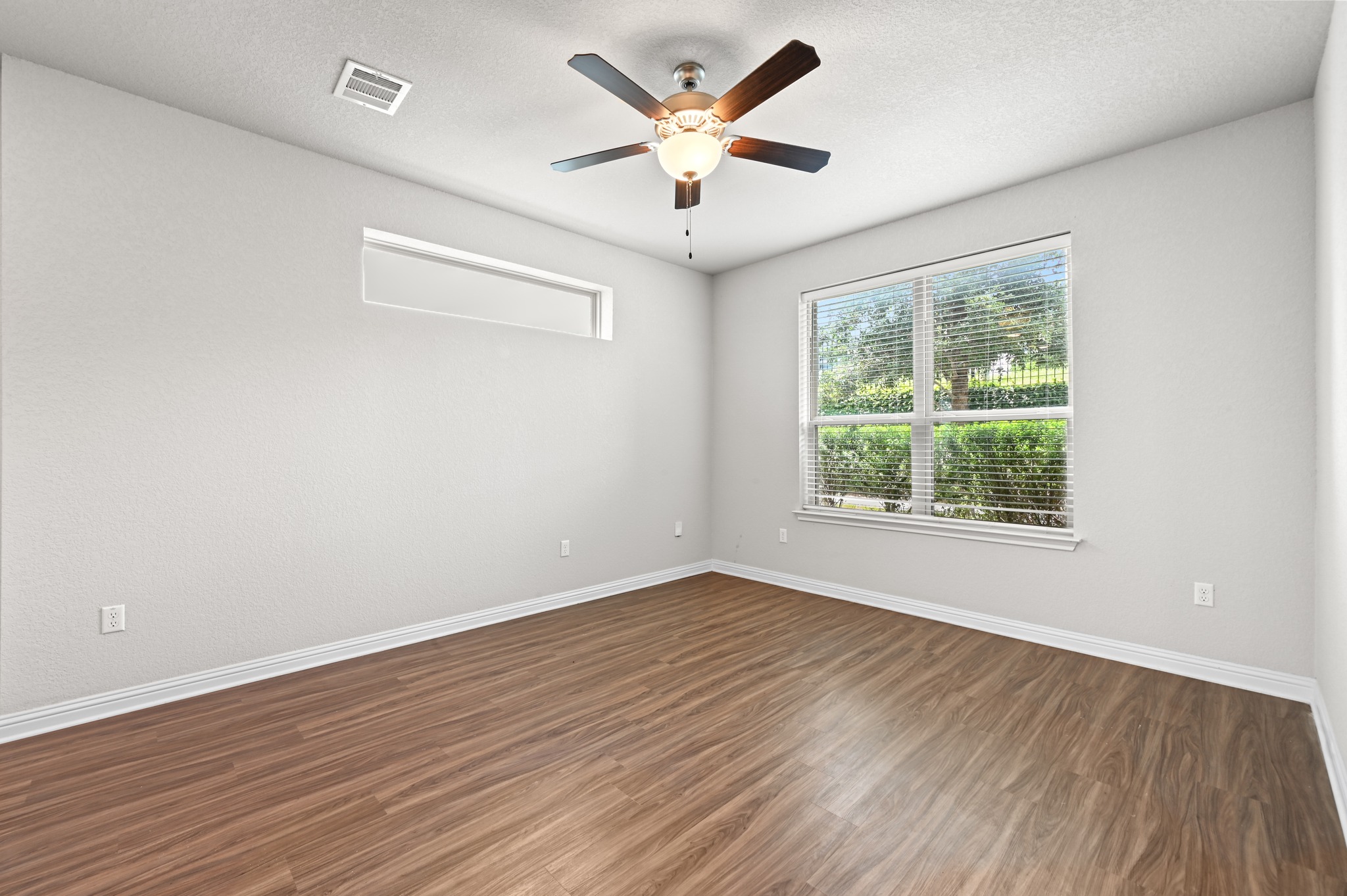 8201 Frida Bend Austin, TX 78744 - Photo 10 of 29 A quiet secondary bedroom features light wood-look flooring and a ceiling fan, offering a tranquil retreat.