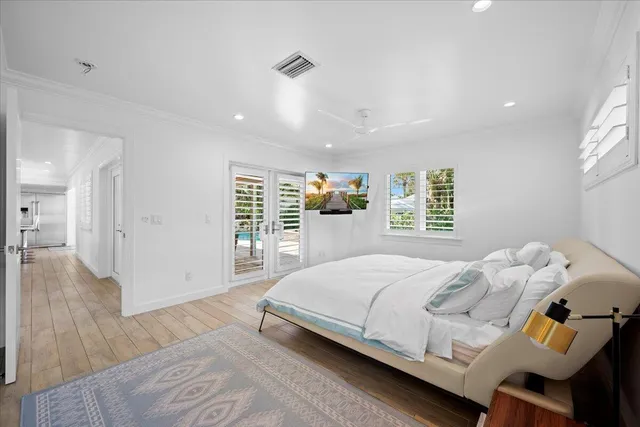 a spacious bedroom with a bed and a flat screen tv