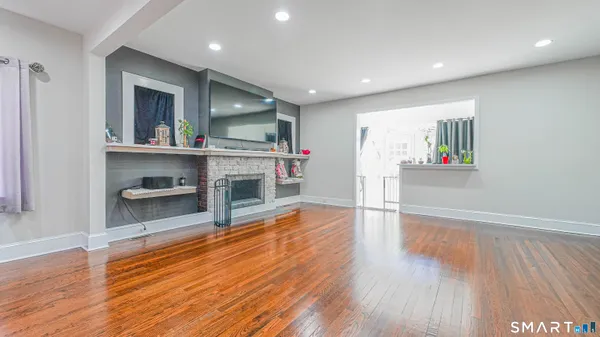 a living room with wooden floor and a fireplace