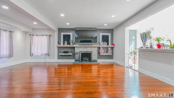 a view of a livingroom with furniture a fireplace and wooden floor