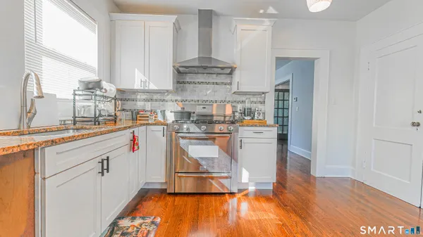 a kitchen with stainless steel appliances granite countertop a refrigerator and a stove top oven