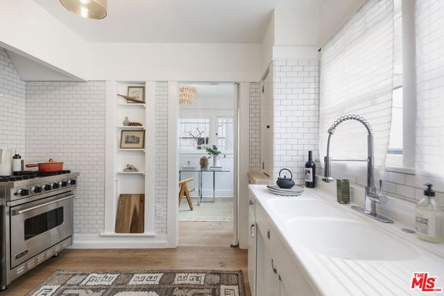 a kitchen with stainless steel appliances a stove a sink and a refrigerator