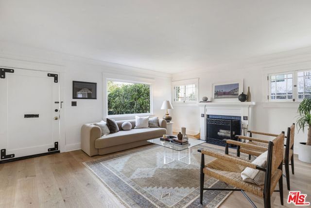 a living room with furniture a fireplace and a large window