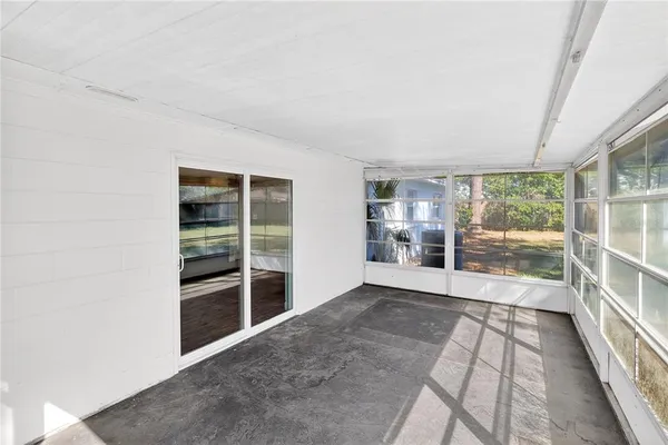 a view of empty room with wooden floor and floor to ceiling window