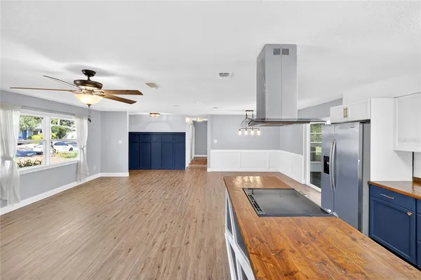 a kitchen with kitchen island a counter top space appliances and a ceiling fan