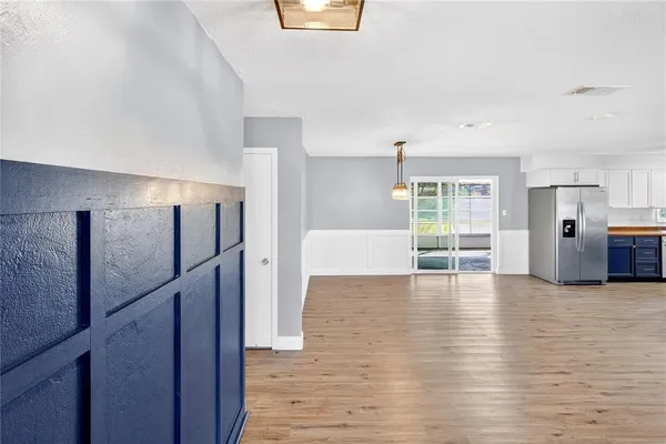 a view of a kitchen with wooden floor and electronic appliances