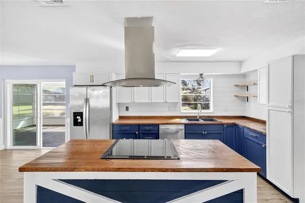 a kitchen with kitchen island sink stove and large window