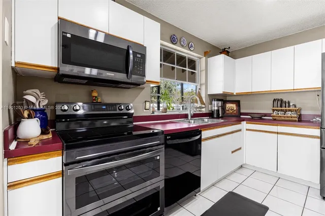 a kitchen with stainless steel appliances a refrigerator sink and cabinets