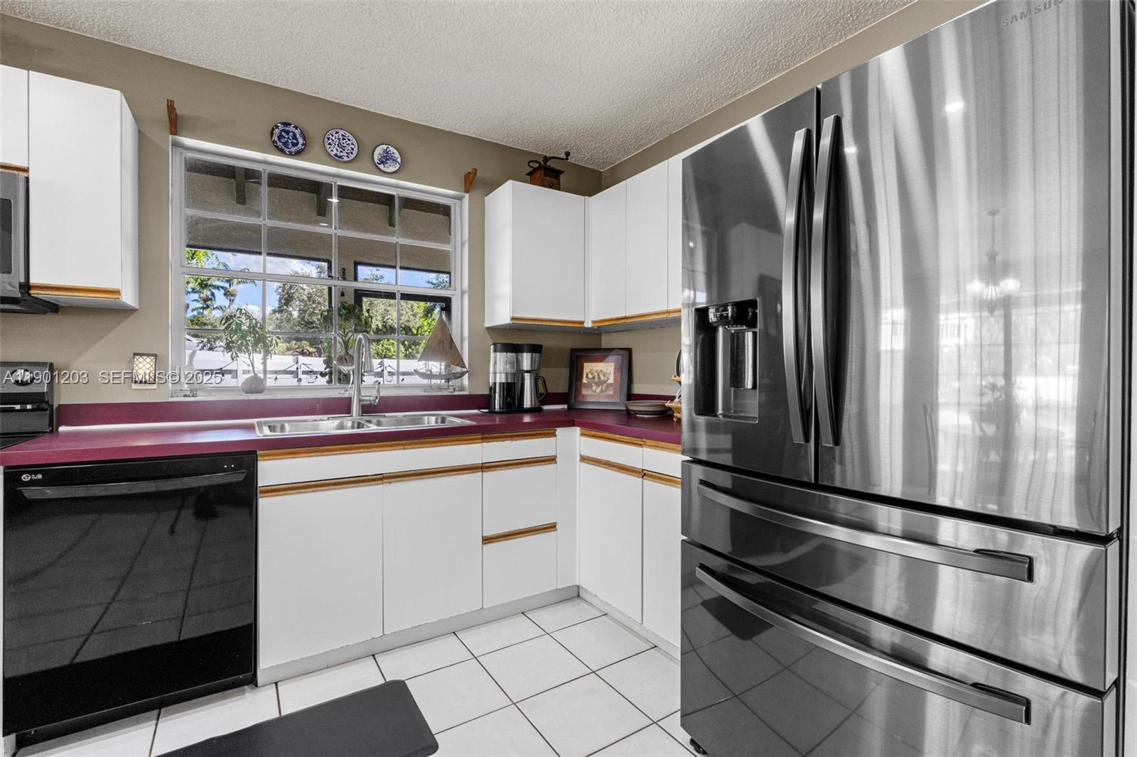 14683 Southwest 145th Terrace Miami, FL 33186 - Photo 16 of 47 a kitchen with stainless steel appliances a refrigerator sink and cabinets