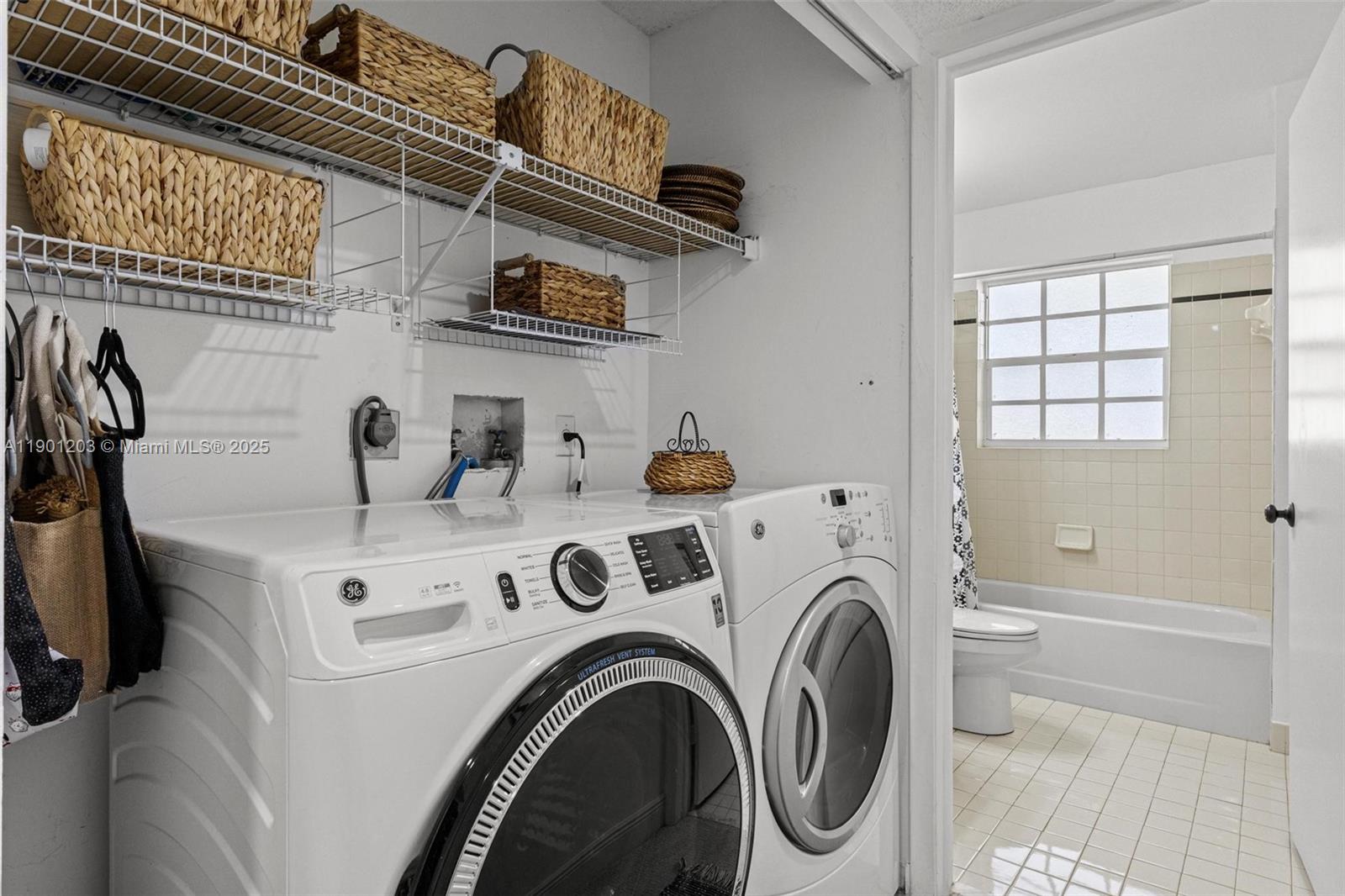 14683 Southwest 145th Terrace Miami, FL 33186 - Photo 20 of 47 a view of washer and dryer with kitchen in the background
