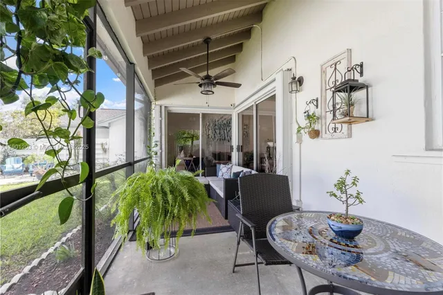 a view of a patio with chairs and potted plants