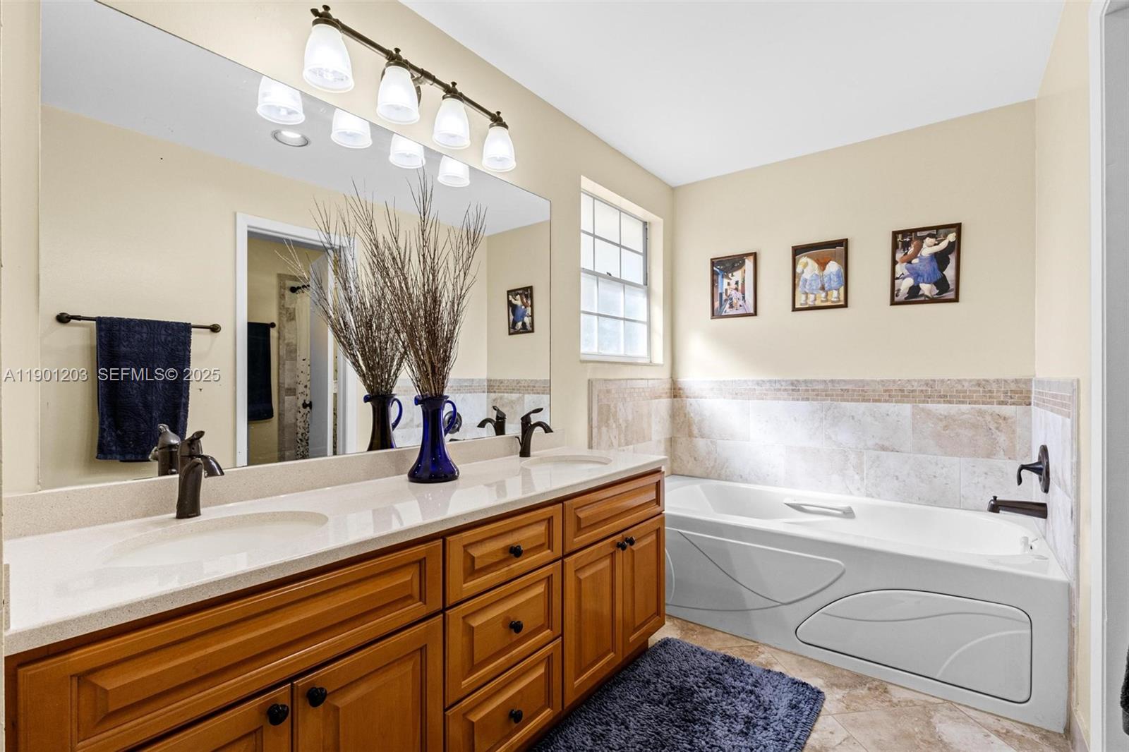 14683 Southwest 145th Terrace Miami, FL 33186 - Photo 26 of 47 a bathroom with a granite countertop sink a large mirror and a bathtub