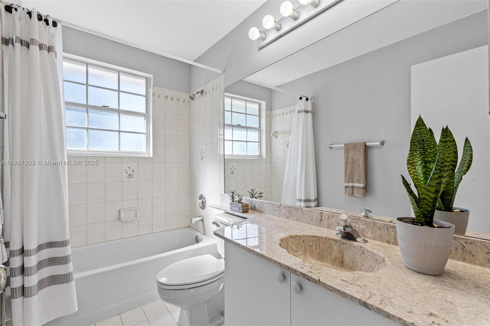 14683 Southwest 145th Terrace Miami, FL 33186 - Photo 30 of 47 a bathroom with a granite countertop sink a toilet a mirror and shower