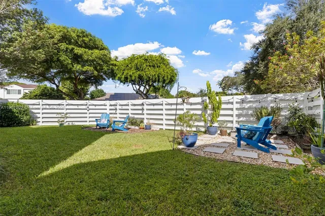 a view of a house with backyard sitting area and garden