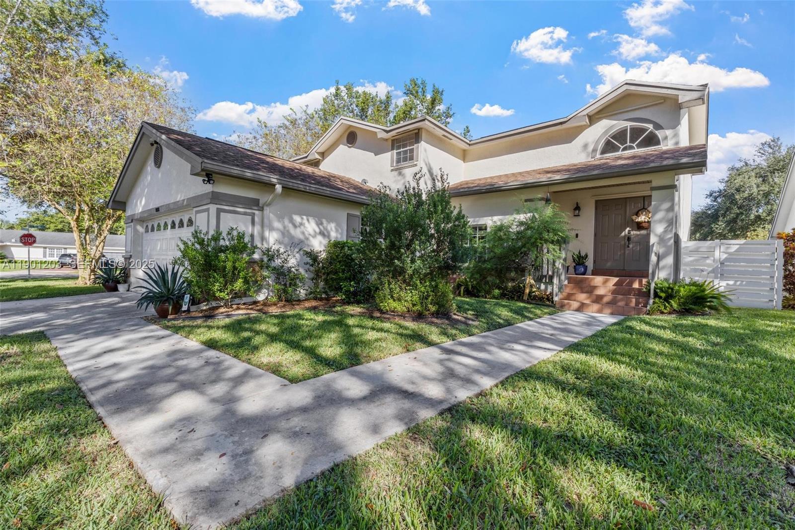 14683 Southwest 145th Terrace Miami, FL 33186 - Photo 34 of 47 a view of a white house with a big yard and potted plants