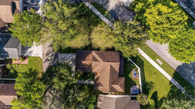 a view of white house with a big yard and large trees