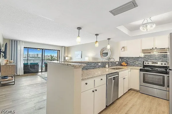a kitchen with stainless steel appliances granite countertop a stove and cabinets