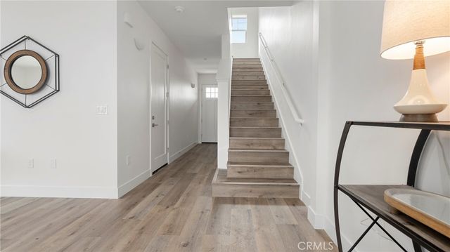 a view of a hallway with wooden floor and staircase
