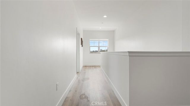 a view of a hallway to a house with wooden floor