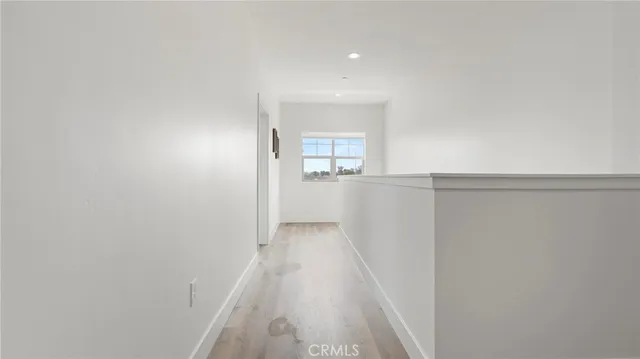a view of a hallway to a house with wooden floor