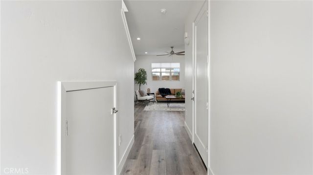 a view of a hallway with a living room with wooden floor