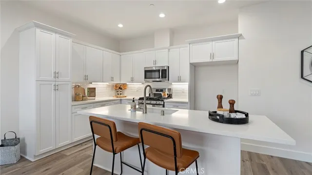 a kitchen with kitchen island granite countertop a sink cabinets and wooden floor
