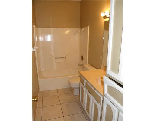 a bathroom with a granite countertop shower and a toilet