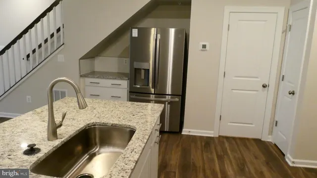 a kitchen with granite countertop a stove and a refrigerator