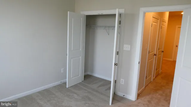 an empty room with window and closet area