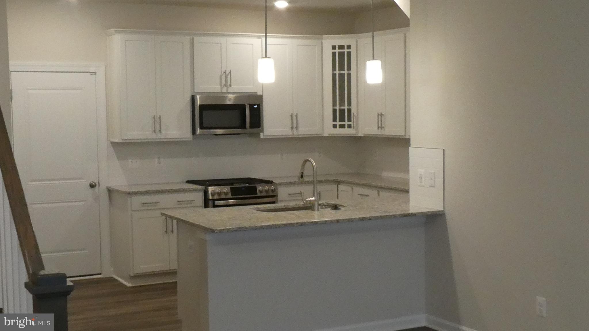 2329 Stephanie Tessa Lane Woodbridge, VA 22191 - Photo 34 of 50 a kitchen with stainless steel appliances granite countertop a sink stove and microwave