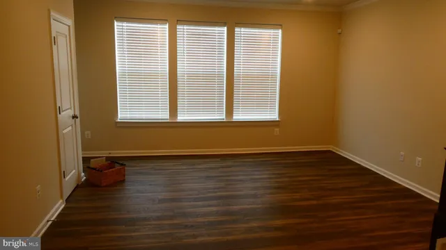 a view of a room with wooden floor and a window