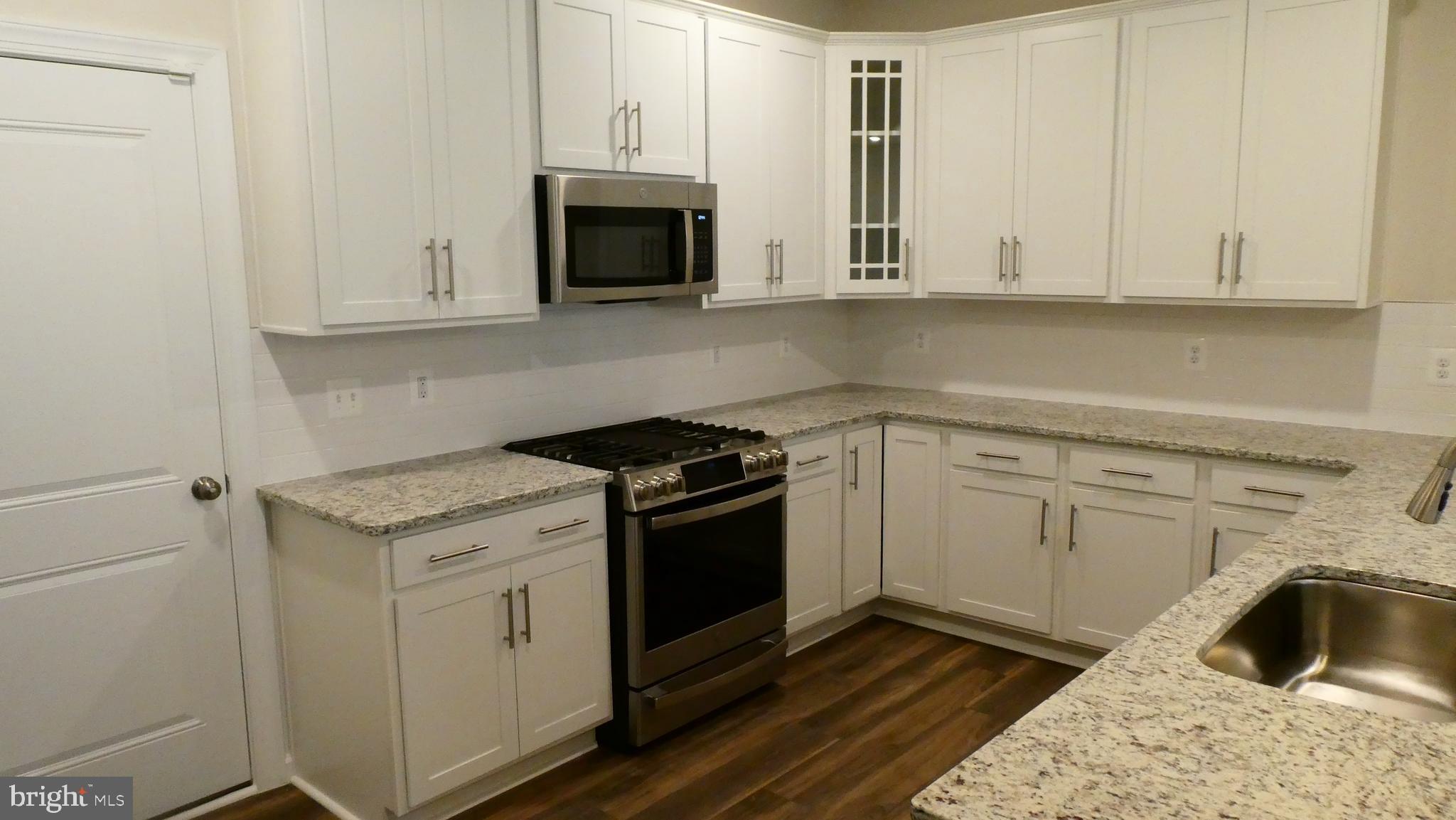 2329 Stephanie Tessa Lane Woodbridge, VA 22191 - Photo 8 of 50 a kitchen with granite countertop white cabinets and a stove