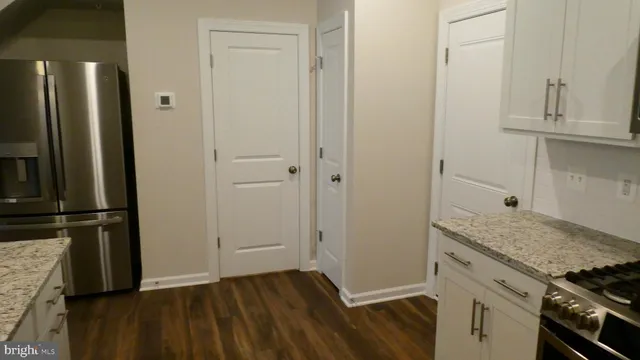 an empty room with wooden floor and cabinets