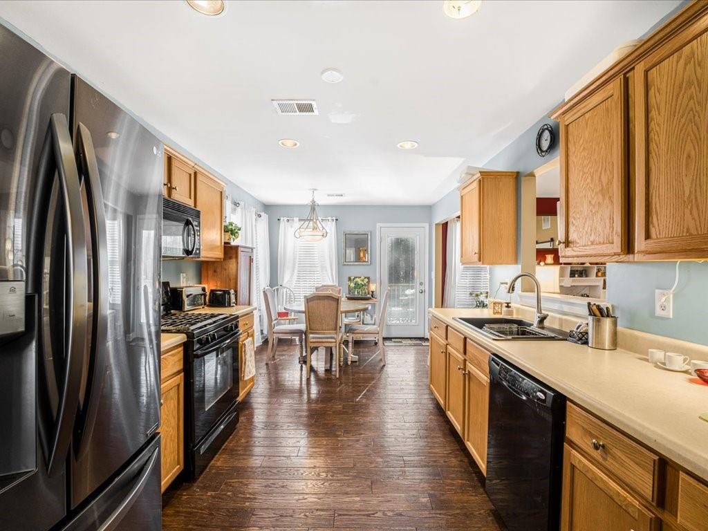 76 Kessle Lane Dallas, GA 30132 - Photo 8 of 33 a kitchen with stainless steel appliances granite countertop a refrigerator a stove top oven a sink dishwasher and white cabinets with wooden floor