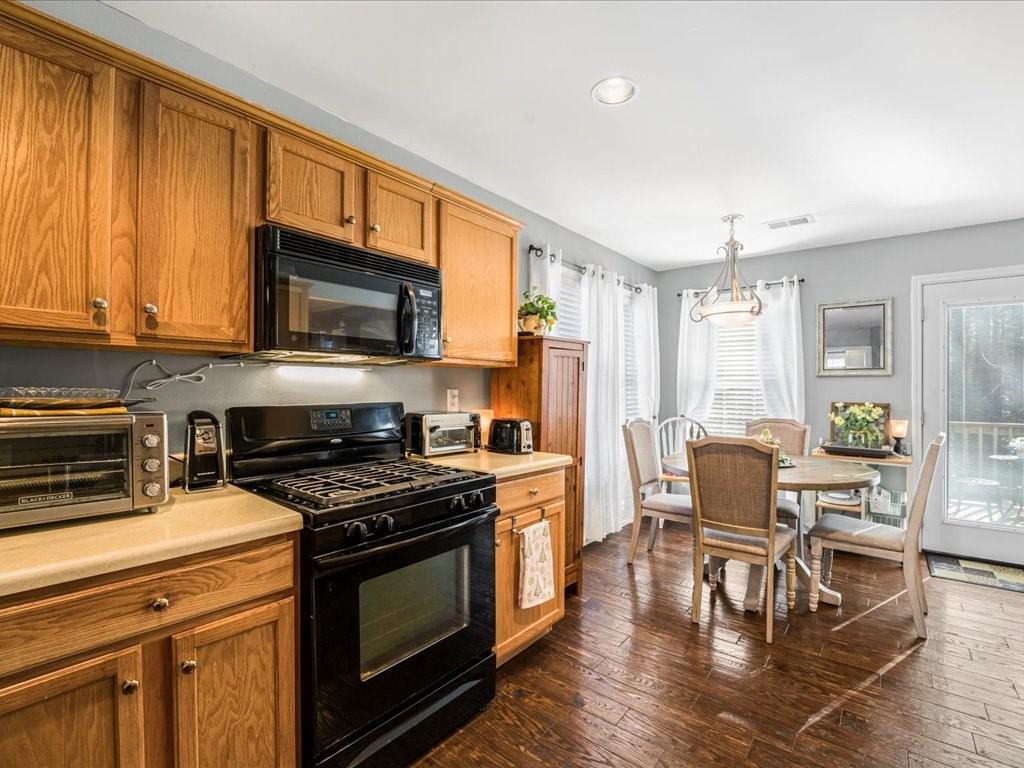 76 Kessle Lane Dallas, GA 30132 - Photo 10 of 33 a kitchen with stainless steel appliances a stove a sink cabinets and a dining table