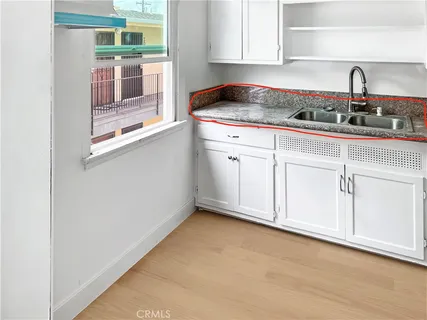 a kitchen with granite countertop white cabinets and a stove