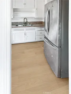 a kitchen with stainless steel appliances white cabinets and a refrigerator