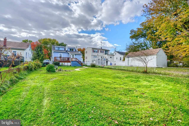 a view of a house with a big yard and large trees