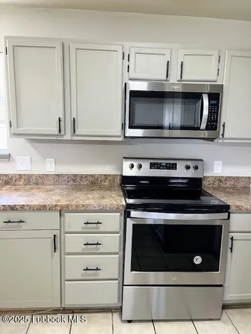 a kitchen with granite countertop a stove microwave and sink