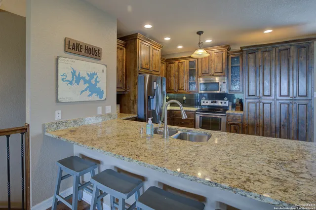 a kitchen with stainless steel appliances granite countertop a sink refrigerator and microwave