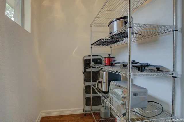 a storage room with wooden floor and cabinets