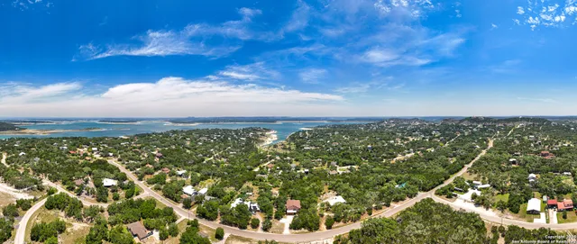 an aerial view of residential houses with outdoor space and trees