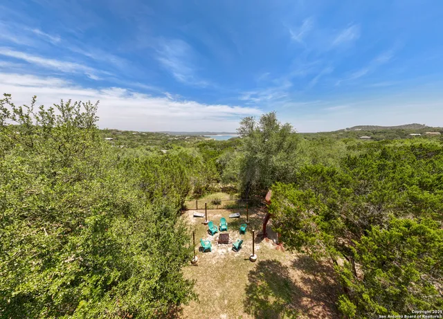 a aerial view of a house with a yard and lake view