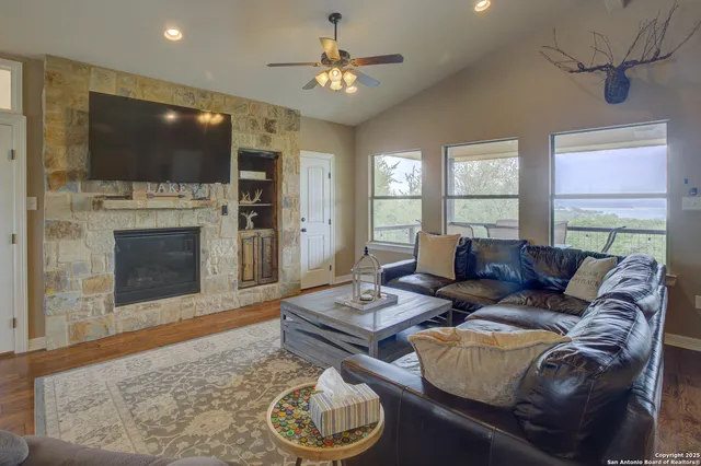 a living room with furniture a flat screen tv and kitchen view