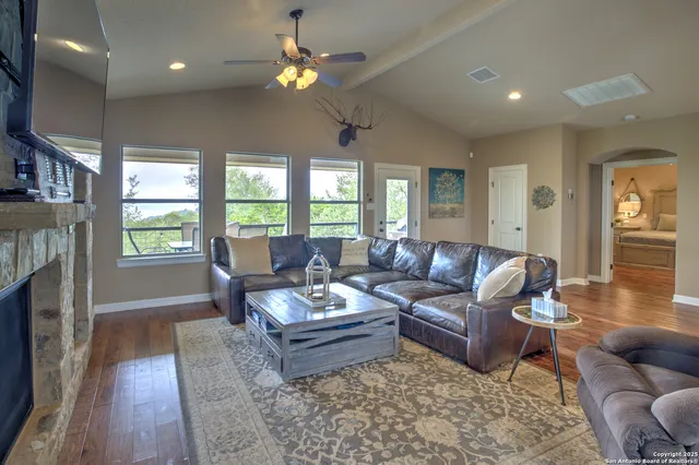 a living room with fireplace furniture and a wooden floor